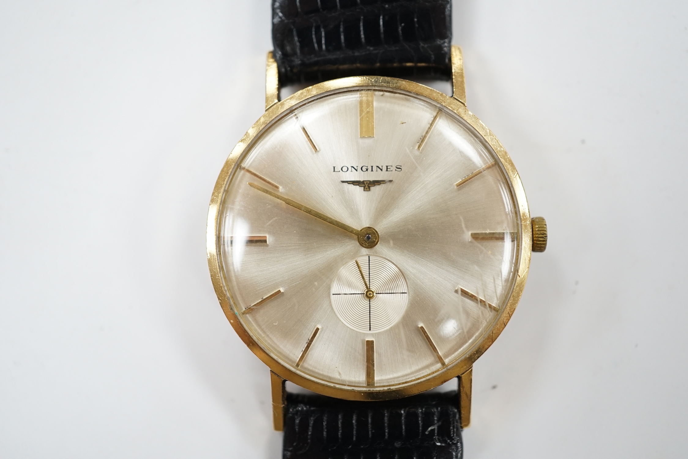 A gentleman's 9ct gold Longines manual wind wrist watch, with case back inscription, on associated leather strap. Condition - poor